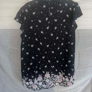 Black blouse with flowers and ruffle sleeves.